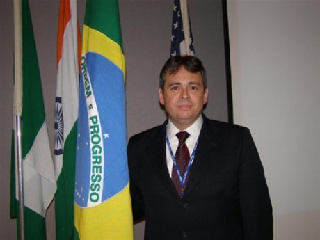 Ricardo Lemos ao lado da bandeira nacional do Brasil, em Cingapura