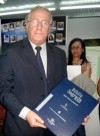 Reitor Prof. Arody de Souza Herdy segurando cópia da Bíblia em Braille doada pela Sociedade Bíblica à Universidade